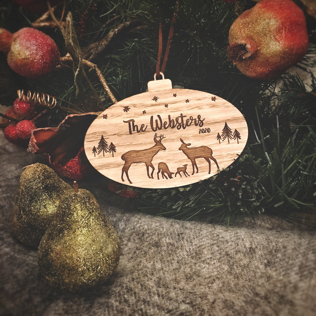 Oval oak bauble engraved with family of deer, Family name and year
